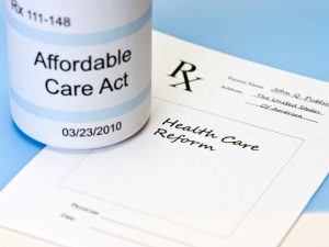 Affordable Care Act prescription bottle on blue with prescription for health care reform.