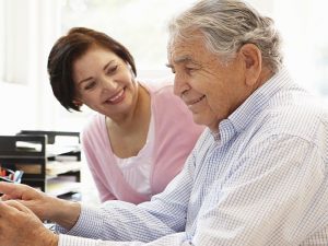 Senior Hispanic couple working on computer at home